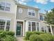 Charming townhome with a well-maintained lawn, and a bright, inviting green front door at 111 Grey Elm Trl, Durham, NC 27713