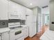 Bright kitchen with white appliances, gray backsplash, and hardwood floors at 111 Grey Elm Trl, Durham, NC 27713