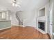 Open-concept living room with hardwood floors, fireplace, and staircase at 111 Grey Elm Trl, Durham, NC 27713