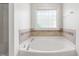 Bright bathroom features bathtub, tile surround, and light at 112 Homegate Cir, Apex, NC 27502