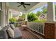 Comfortable front porch with white railings, wood floors, ceiling fan, and cozy seating options at 112 Homegate Cir, Apex, NC 27502