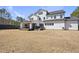 Large backyard with a covered patio, dark-stained wood deck, and lush lawn with some dead spots at 113 Amberwing Ct, Holly Springs, NC 27540