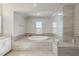 Bright bathroom showcasing an integrated tub and shower with neutral toned finishes at 113 Amberwing Ct, Holly Springs, NC 27540