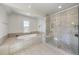 Modern bathroom featuring a soaking tub and separate glass enclosed shower at 113 Amberwing Ct, Holly Springs, NC 27540