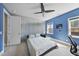 Stylish bedroom boasting a corrugated metal wall, fan, and large windows for natural light at 113 Amberwing Ct, Holly Springs, NC 27540