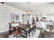 An open dining area shows wood floors, a modern light fixture, and connects seamlessly to the white kitchen at 113 Amberwing Ct, Holly Springs, NC 27540