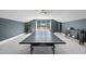 Upstairs game room featuring a ping pong table, gray walls, and a large window with natural light at 113 Amberwing Ct, Holly Springs, NC 27540