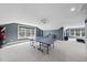 Spacious upstairs game room featuring a ping pong table, gray walls, and bright windows at 113 Amberwing Ct, Holly Springs, NC 27540