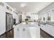 Bright, white kitchen with stainless steel appliances, large island, and ample cabinet space at 113 Amberwing Ct, Holly Springs, NC 27540