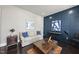 Comfortable living room with blue accent wall, plush sofa, and dark wood floors at 113 Amberwing Ct, Holly Springs, NC 27540