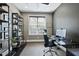 Well-lit home office features a window, shelving, and desk, perfect for a productive work environment at 113 Amberwing Ct, Holly Springs, NC 27540