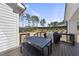 Outdoor patio featuring a dark table with bench seating, a grill, and access to a lawn with trees at 113 Amberwing Ct, Holly Springs, NC 27540