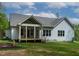 Rear view of the home with a covered porch, multiple windows, and light-blue siding at 1218 Red Cedar Ct, Youngsville, NC 27596