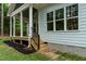 Detailed view of the covered back porch with stairs leading to the yard and light-blue accents at 1218 Red Cedar Ct, Youngsville, NC 27596