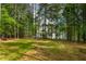 Expansive backyard with mature trees and a view of the home's exterior at 1218 Red Cedar Ct, Youngsville, NC 27596