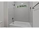 Tile shower/bath enclosure features grey subway tiles, shower head, and a window at 1218 Red Cedar Ct, Youngsville, NC 27596