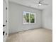 This bedroom offers a ceiling fan, carpeted floors, and a window overlooking the beautiful green space at 1218 Red Cedar Ct, Youngsville, NC 27596