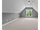 Spacious bonus room featuring neutral carpet, a window with tree views, and a modern ceiling fan at 1218 Red Cedar Ct, Youngsville, NC 27596