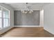 Dining room with modern light fixture, accent wall, and wood-look floors at 1218 Red Cedar Ct, Youngsville, NC 27596