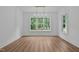 Sun-filled dining area with hardwood floors, a modern chandelier, and expansive windows overlooking lush greenery at 1218 Red Cedar Ct, Youngsville, NC 27596
