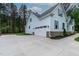 Spacious driveway leading to a home featuring light blue siding and a white garage door at 1218 Red Cedar Ct, Youngsville, NC 27596