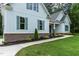 Close-up of a charming home featuring light blue siding, green shutters, brick accents, and meticulously maintained landscaping at 1218 Red Cedar Ct, Youngsville, NC 27596