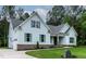 A charming home featuring light blue siding, green shutters, brick accents, and meticulously maintained landscaping at 1218 Red Cedar Ct, Youngsville, NC 27596