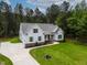 Charming two-story home with light blue siding, green shutters, manicured landscaping, and a spacious driveway at 1218 Red Cedar Ct, Youngsville, NC 27596