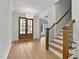 Welcoming foyer with wood floors, staircase, and a stylish light fixture at 1218 Red Cedar Ct, Youngsville, NC 27596