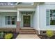 Close-up of the front door, featuring brick steps, a hanging lantern, and light-blue siding at 1218 Red Cedar Ct, Youngsville, NC 27596