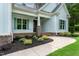 Inviting front porch with brick accents and detailed landscaping at a home with light blue siding at 1218 Red Cedar Ct, Youngsville, NC 27596