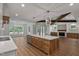 Open-concept living space featuring a large kitchen island, fireplace, and abundant natural light at 1218 Red Cedar Ct, Youngsville, NC 27596