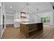 Bright kitchen features a large island, stainless steel appliances, and stylish lighting fixtures at 1218 Red Cedar Ct, Youngsville, NC 27596