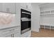Kitchen featuring stainless steel appliances, white shaker cabinets, and open pantry at 1218 Red Cedar Ct, Youngsville, NC 27596