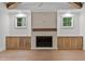 Living room fireplace with wooden mantel and built-in cabinets at 1218 Red Cedar Ct, Youngsville, NC 27596