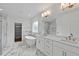 Luxurious main bathroom with dual sinks, a soaking tub, marble flooring, and a glass-enclosed shower at 1218 Red Cedar Ct, Youngsville, NC 27596