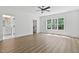 Bright main bedroom featuring a ceiling fan, hardwood floors, and a large window overlooking the lush yard at 1218 Red Cedar Ct, Youngsville, NC 27596