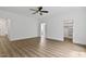 Bright main bedroom featuring wood-look flooring, adjoined by a bathroom and walk in closet at 1218 Red Cedar Ct, Youngsville, NC 27596
