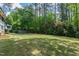 Lush backyard with mature trees and green lawn at 1305 Kimberly Dr, Raleigh, NC 27609