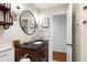 Elegant bathroom featuring a dark wood vanity, a stone countertop, and a decorative round mirror at 1305 Kimberly Dr, Raleigh, NC 27609