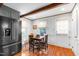 Cozy dining area features hardwood floors, neutral walls, and a stainless steel refrigerator at 1305 Kimberly Dr, Raleigh, NC 27609
