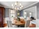 Stylish dining room with textured wallpaper, a chandelier, and views into an adjacent living area at 1305 Kimberly Dr, Raleigh, NC 27609