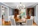 Elegant dining room featuring a chandelier, wallpapered walls, and a round table with seating for six at 1305 Kimberly Dr, Raleigh, NC 27609
