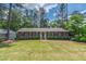 Charming single-story home with a manicured lawn, brick pathway, and lush green landscaping at 1305 Kimberly Dr, Raleigh, NC 27609