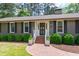 Inviting front entrance with a brick walkway, decorative plants, and a classic dark-stained door at 1305 Kimberly Dr, Raleigh, NC 27609