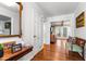 Inviting foyer featuring wood floors, a decorative mirror, and a glimpse into a sunlit living area at 1305 Kimberly Dr, Raleigh, NC 27609