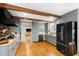 A modern kitchen with gray cabinets, wood beams, butcher block and granite countertops, and stainless steel appliances at 1305 Kimberly Dr, Raleigh, NC 27609