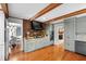 Bright kitchen with gray cabinets, brick accents, stainless appliances, and a view into the dining area at 1305 Kimberly Dr, Raleigh, NC 27609