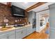 This kitchen features gray cabinets, stainless appliances, brick accents, and butcher block countertops at 1305 Kimberly Dr, Raleigh, NC 27609
