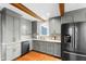 A well-lit kitchen boasts gray cabinets, stainless steel appliances, wooden beams and granite countertops at 1305 Kimberly Dr, Raleigh, NC 27609